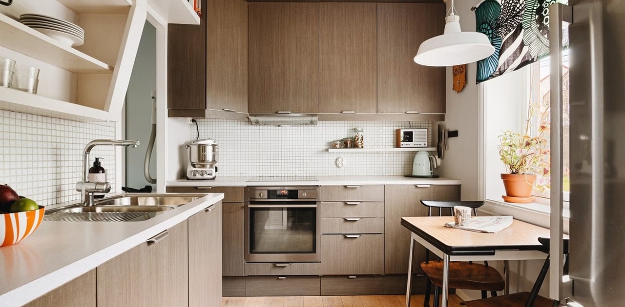 Flott kjøkken med mange overflater, induksjonstopp, stekeovn, stort kjøleskap og fryser, og mer.