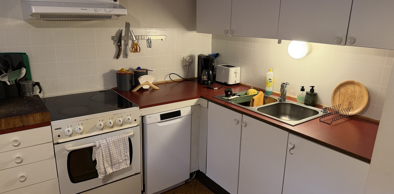 Enkelt kjøkken med spiseplass. Oppvaskmaskin og kjøleskap/frys er av nyere dato.