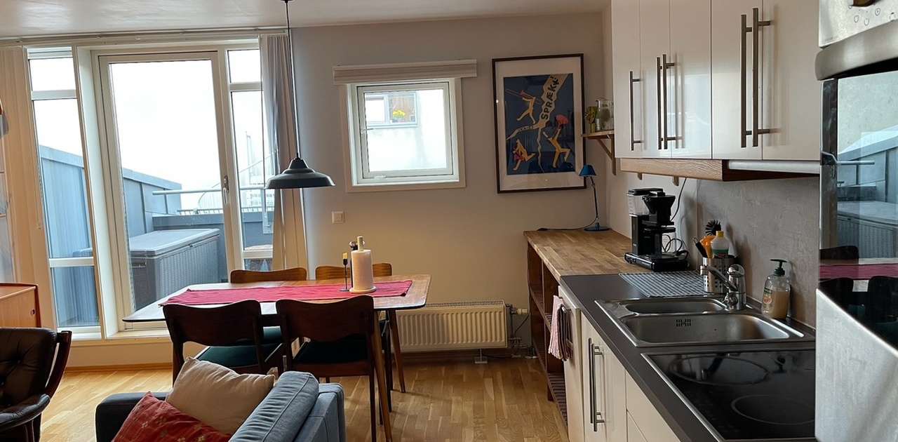 Kjøkken/stue sett fra inngangsparti. Utgang til veranda med sittegruppe til venstre.