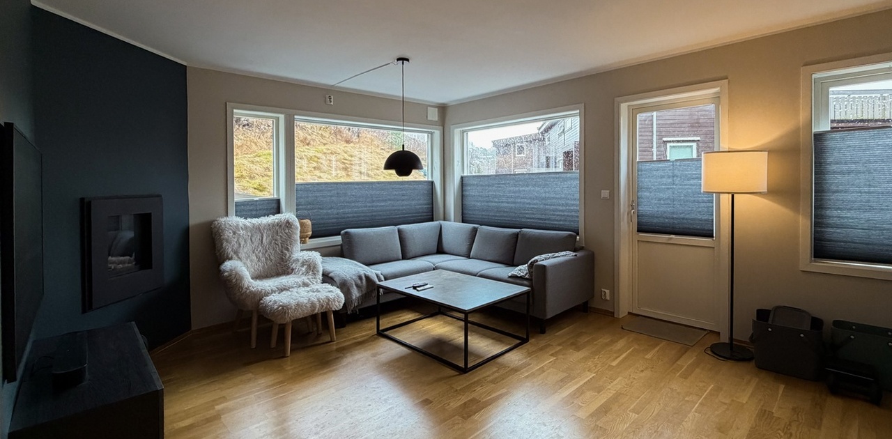Romslig stue med store vinduer og mye naturlig lys