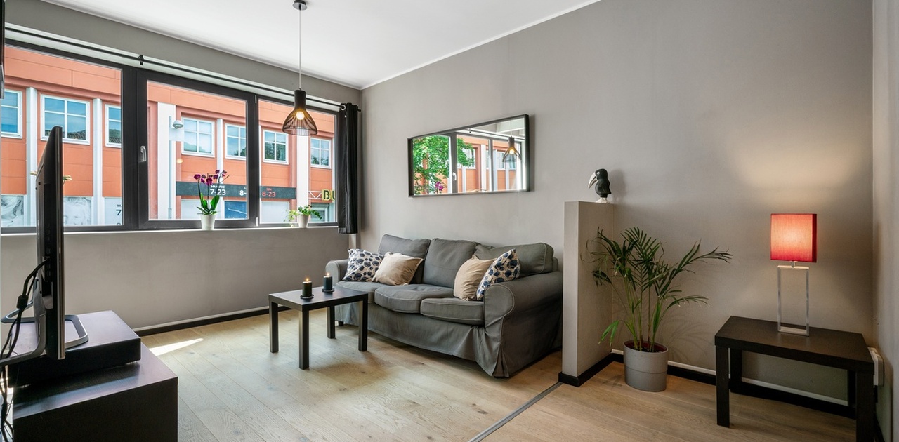 Stuen har plass til sofa med tilhørende møblement og det er også lagt opp til arbeidsstasjon eller hjemmekontor -