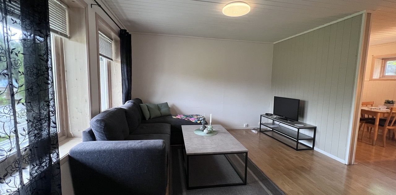 Stue med store vinduer mot hage
