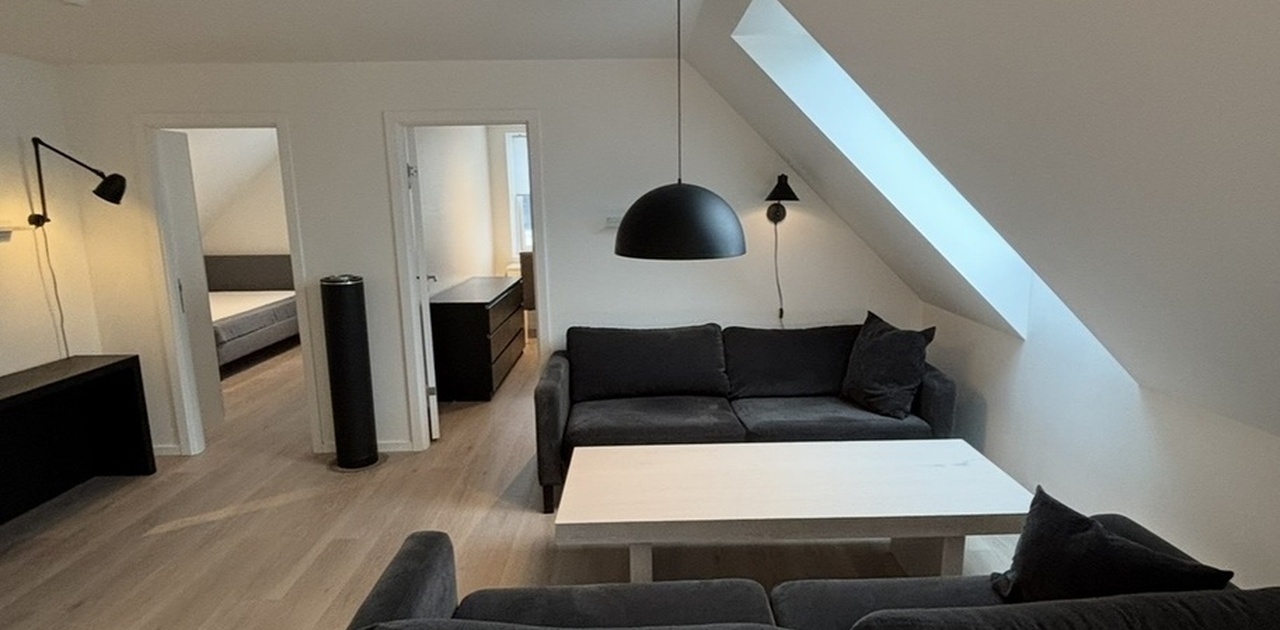 Åpen stue med møbler som sofa og stuebord