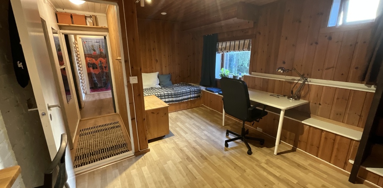 Oppholdsrom med skrivepult og seng