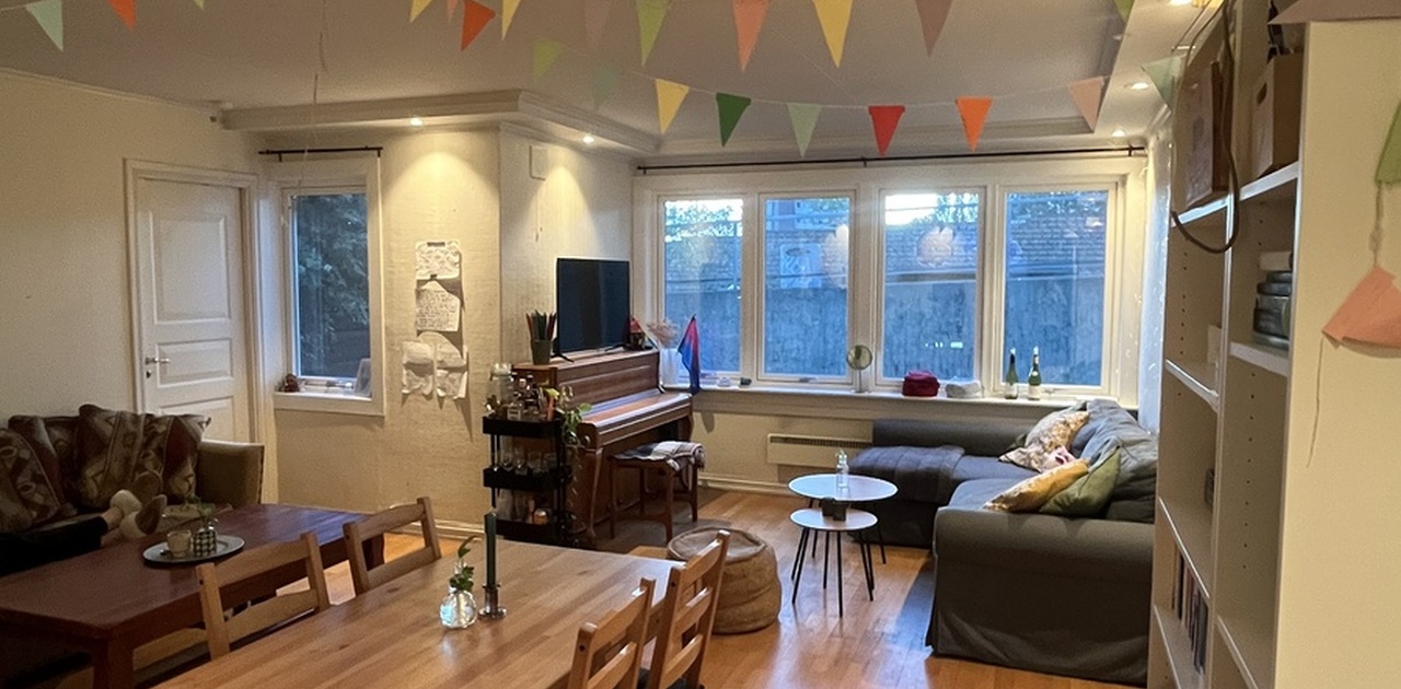 Stor stue med mye sitteplass, TV og piano