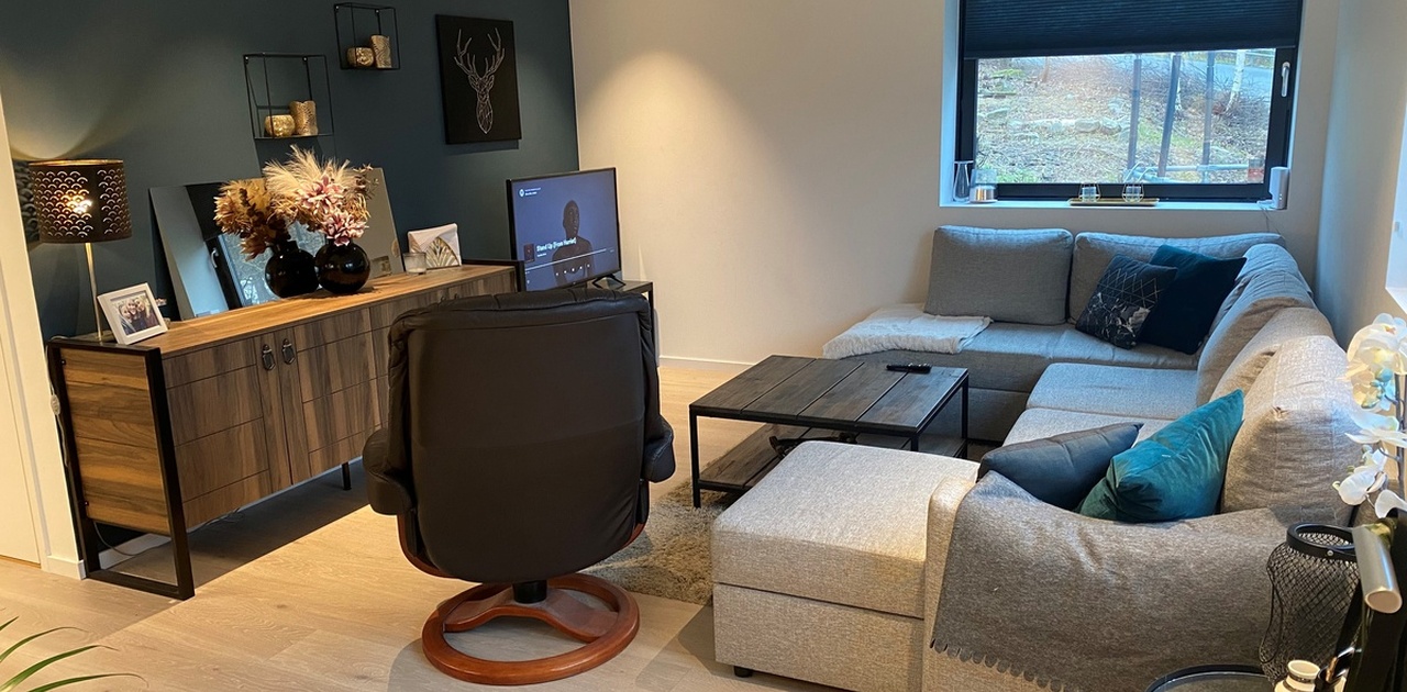 Romslig stue med sofa og store vinduer