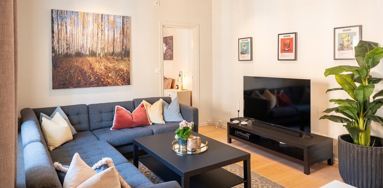 Stue med stor sofa og TV