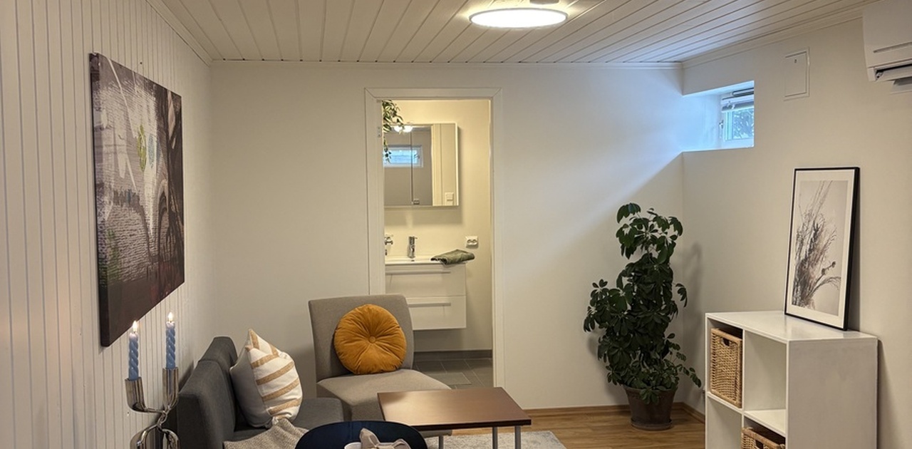 Koselig stue og kjøkken. Badet er i enden av bildet.