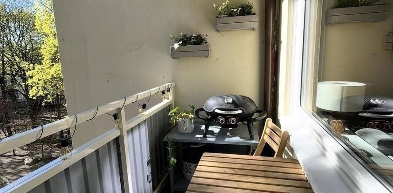 Balkong med utsikt mot grønn bakhage.