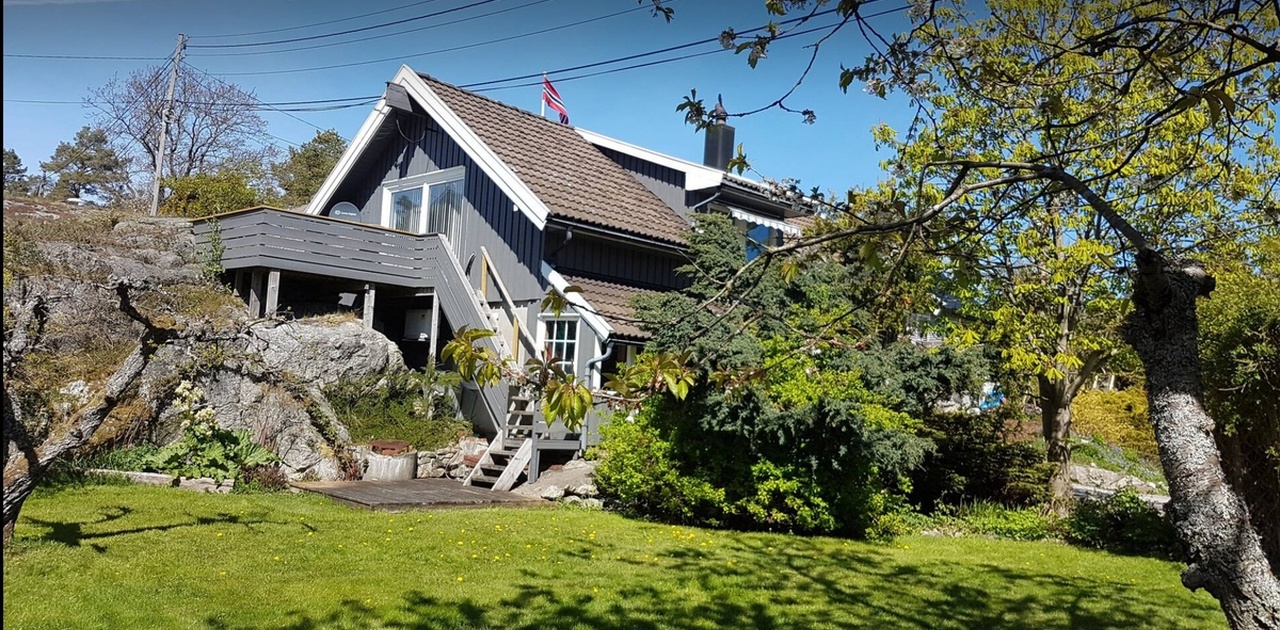 Terrasse og platting med utgagng fra stor skyvedør på kjøkken