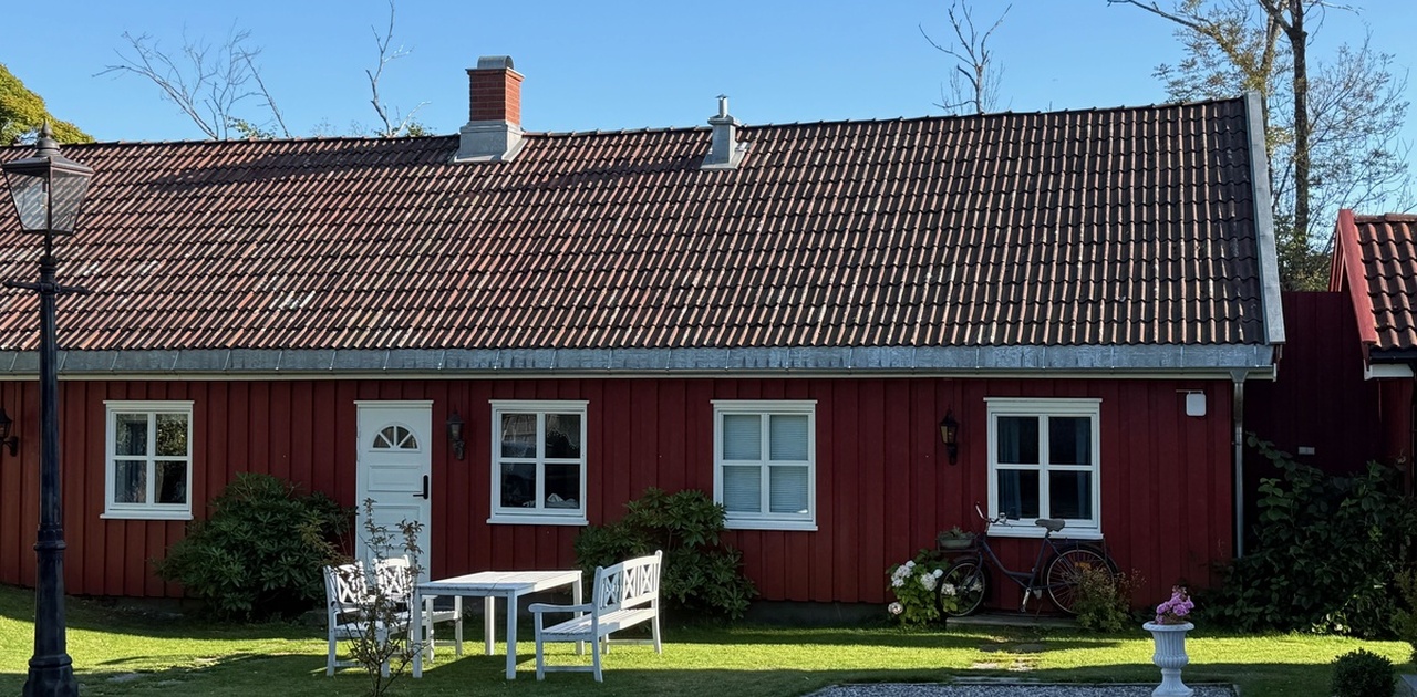 Leiligheten sett fra tunet – egen inngang, og alle fire vinduene hører til leiligheten.