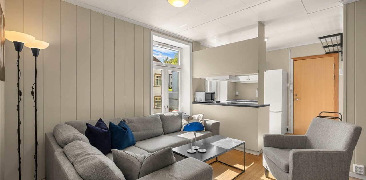 The flat features a large common area with a kitchen, living room and dining table