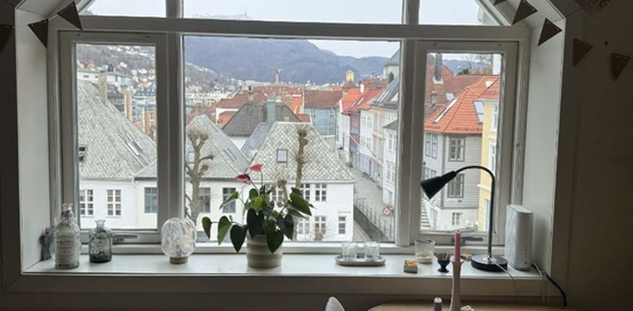 Fra spise- og arbeidsplassen er det flott utsikt mot sjarmerende bytak og fjell gjennom det karakteristiske vinduet.