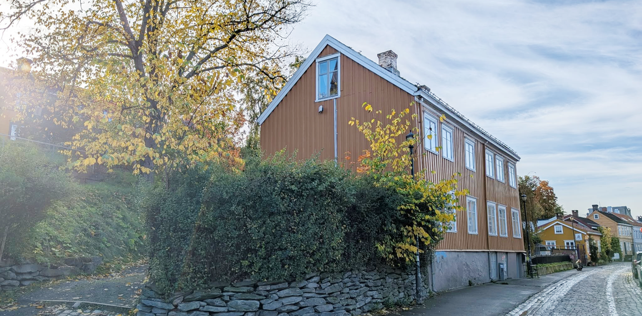 Fasade. Sykkelparkering bak hekken.
