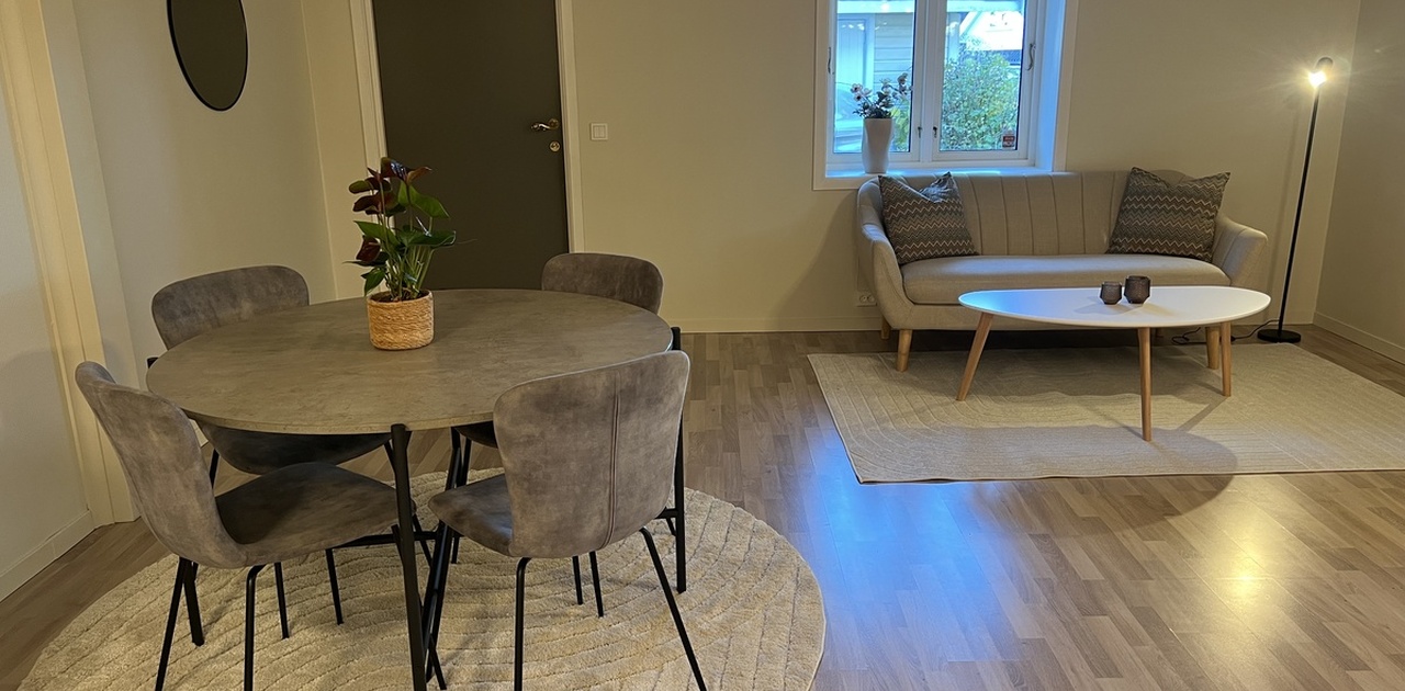 Stuen er innredet med spisebord og sofa