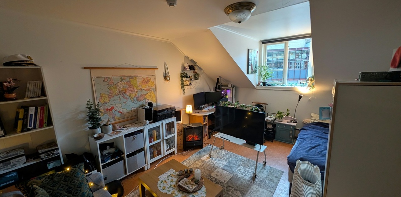 Soverommet under skråtaket har plass til både sofa, salongbord, TV-stativ, skrivepult og seng.Stort soverom med plass til alt du trenger - brukes nå som egen stue og soverom kombinert. - godt med naturlig lys utenfra